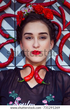 Beautiful young woman between a chili pepper lying on the checkered floor
