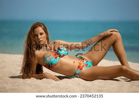 Beautiful young woman in bikini on the beach near the sea. High quality photo