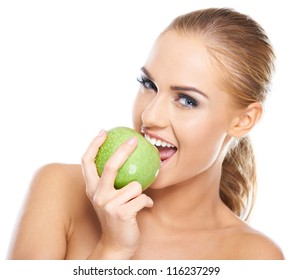 Beautiful  young woman bites a green apple on white
