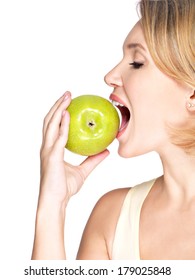 Beautiful young woman biting the biting a fresh ripe apple - on white background.