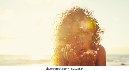 Beautiful Young Woman Blowing Glitter On The Beach At Sunset