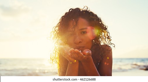 Beautiful young woman blowing glitter on the beach at sunset - Powered by Shutterstock