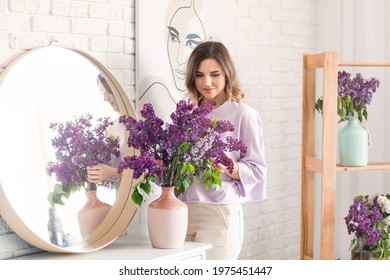 Beautiful Young Woman With Bouquet Of Lilac Flowers At Home