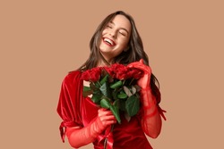 Beautiful Young Woman With Bouquet Of Red Roses On Brown Background. Valentine's Day Celebration