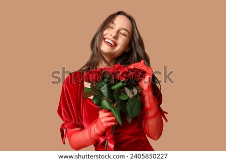 Beautiful young woman with bouquet of red roses on brown background. Valentine's Day celebration
