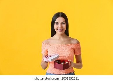 Beautiful Young Woman With Box Of Chocolate Candies On Color Background