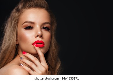 Beautiful young woman with bright makeup and neon pink nails. Beauty face. Photo taken in the studio.