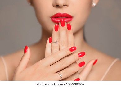 Beautiful young woman with bright manicure on color background, closeup. Nail polish trends
