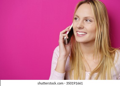 Beautiful Young Woman Calling On The Phone Against Pink Background In The Studio