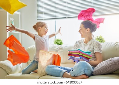 Beautiful young woman and child girl little helper are having fun and smiling while doing laundry at home. - Powered by Shutterstock