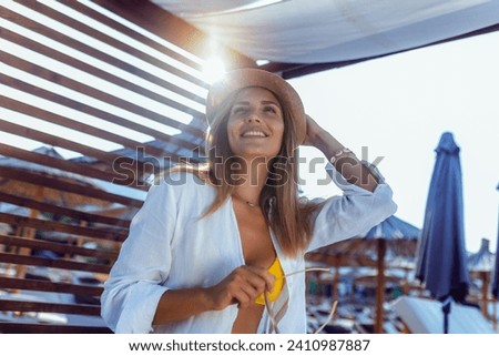 Beautiful young woman chilling on deck chair on the beach.