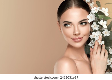 Beautiful young woman with clean fresh skin touching her face in flowers  . Girl facial  treatment   . Cosmetology , beauty  and spa . Female  model, care concept  - Powered by Shutterstock