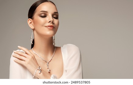 Beautiful young woman with clean fresh skin on face . Girl in white dress and silver jewelry , facial  treatment   . Cosmetology , beauty  and spa .