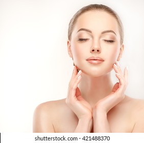 Beautiful Young Woman with Clean Fresh Skin  touch her face . Facial  treatment   . Cosmetology , beauty  and spa .

