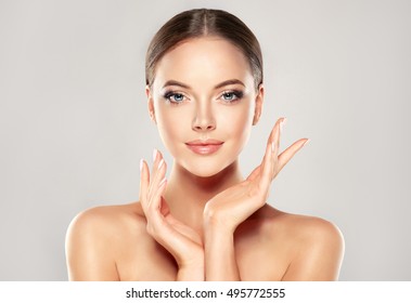 Beautiful Young Woman with Clean Fresh Skin  touch own face . Facial  treatment   . Cosmetology , beauty  and spa . - Shutterstock ID 495772555