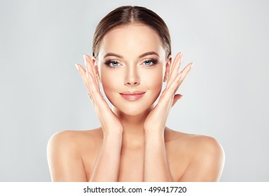 Beautiful Young Woman With Clean Fresh Skin  Touch Own Face . Facial  Treatment   . Cosmetology , Beauty  And Spa .