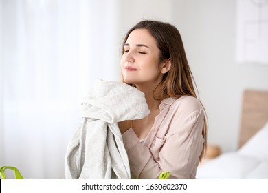 Beautiful Young Woman With Clean Laundry At Home