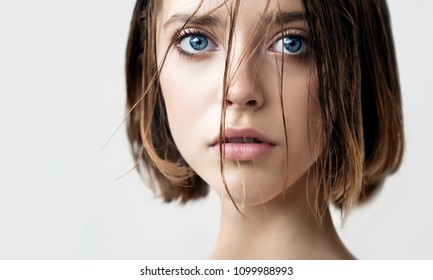 Beautiful Young Woman With Clean Perfect Skin And Wet Hair. Portrait Of Beauty Model With Natural Nude Makeup Moisturizing Her Skin. Spa, Skincare And Wellness. Close Up, Background, Copy Space.