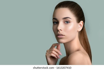 Beautiful Young  Woman With Clean Perfect Fresh Skin Touching Her Face. Portrait Of Beauty Model With Natural Make Up,  Formed Eyebrows  And Long Eyelashes.  Spa, Skincare And Wellness.