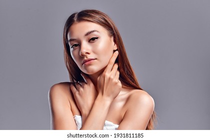 Beautiful Young Woman With Clean Perfect Skin. Portrait Of Beauty Model With Natural Nude Makeup. Spa, Skin Care And Wellness. Close Up, Gray Background, Copyspace.