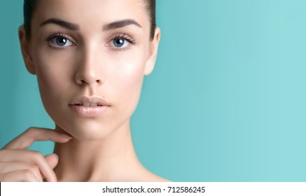 Beautiful young woman with clean perfect skin. Portrait of beauty model with natural nude make up and long eyelashes. Spa, skincare and wellness. Close up, background, copyspace. 