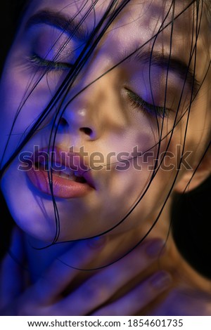 Young woman in black lingerie in chiaroscuro lighting