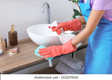 Beautiful Young Woman Cleaning Bathroom