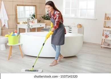 Beautiful young woman cleaning bathroom