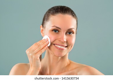 beautiful young woman cleansing facial skin with a napkin