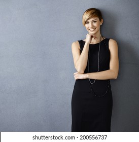 Beautiful Young Woman In Cocktail Dress On Gray Background