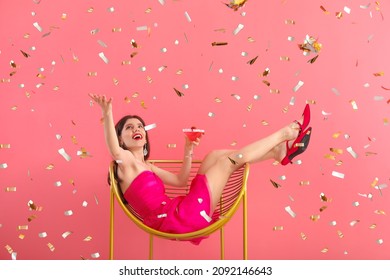 Beautiful young woman with cocktail sitting in armchair on color background - Powered by Shutterstock