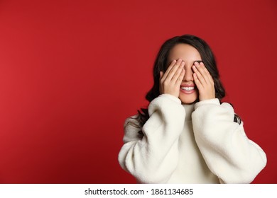 Beautiful young woman covering her eyes on red background, space for text. Christmas party - Shutterstock ID 1861134685
