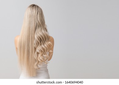 Beautiful young woman with curly and straight hair on light background - Shutterstock ID 1640694040