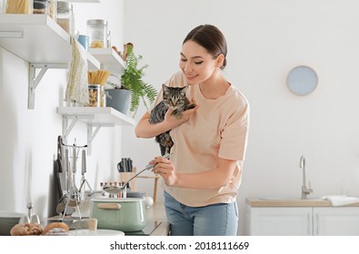 Beautiful Young Woman With Cute Cat Cooking In Kitchen