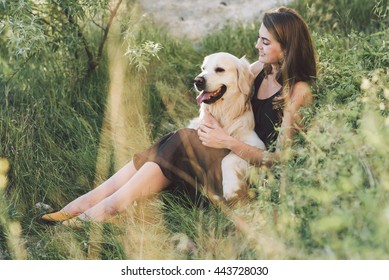 Beautiful and young woman with a cute golden retriever dog