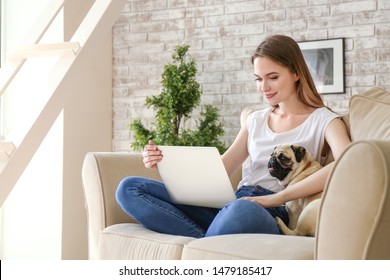 Beautiful Young Woman With Cute Pug Dog Working On Laptop At Home