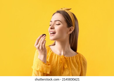 Beautiful young woman with delicious chocolate candy on color background - Shutterstock ID 2145830621