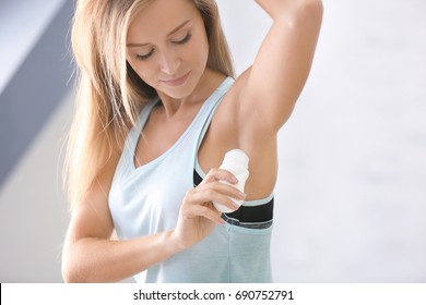 Красивая молодая женщина с дезодорантом в домашних условиях