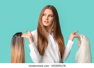 Beautiful young woman with different wigs on color background