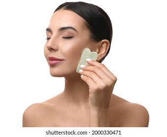 Beautiful Young Woman Doing Facial Massage With Gua Sha Tool On White Background