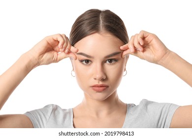 Beautiful Young Woman Doing Facial Yoga On White Background