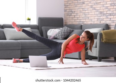Belle jeune femme faisant de l'exercice physique à la maison