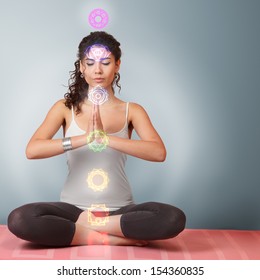 Beautiful Young Woman Doing Yoga Meditation In Lotus Position With Activated Chakras Over Body