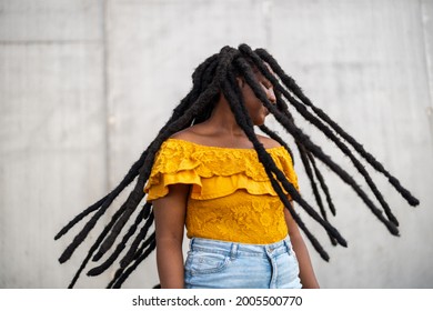 Beautiful young woman with dreadlocks in front of gray wall
 - Powered by Shutterstock