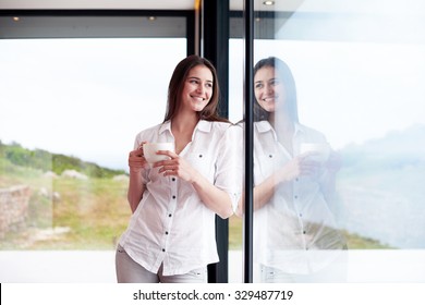 Beautiful Young Woman Drink First Morning Coffee At Modern Home Interior With Rain Drops On Big Window Door Glass