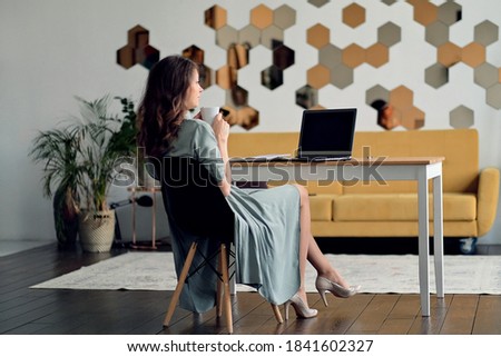 beautiful young woman drinking coffee. businesswoman working from home office. Freelancer using laptop and the Internet. Workplace in living room.