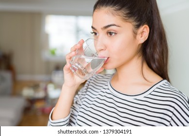 Beautiful young woman drinking a fresh glass of water at home - Shutterstock ID 1379304191
