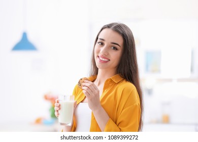Beautiful young woman drinking milk with cookies at home - Shutterstock ID 1089399272