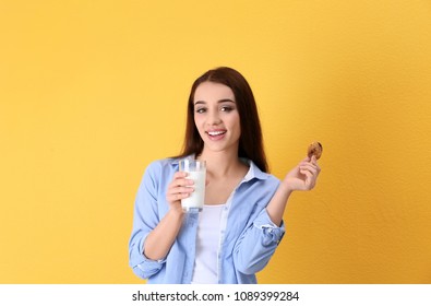 Beautiful young woman drinking milk with cookie on color background - Shutterstock ID 1089399284