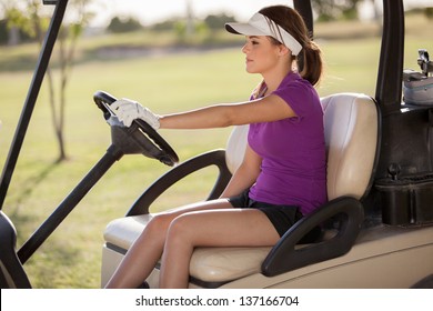 Beautiful young woman driving a golf cart on a sunny day